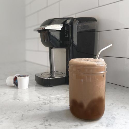 iced coffee with cocoa almond foam sirring on coffee with keurig